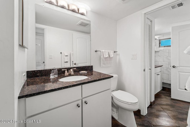 bathroom featuring tile patterned flooring, vanity, and toilet