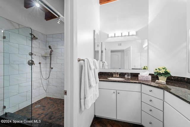 bathroom with vanity and tiled shower