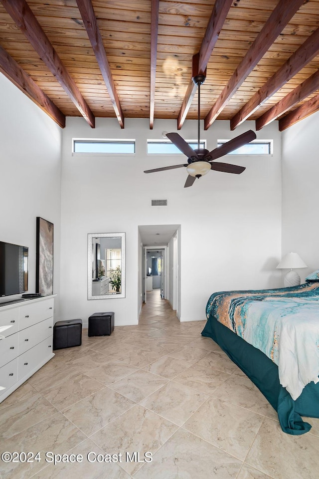 bedroom with beam ceiling, ceiling fan, wooden ceiling, and a high ceiling