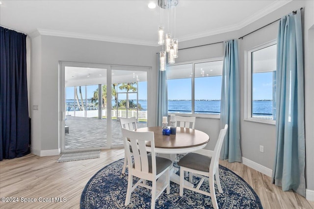 dining space featuring ornamental molding and light wood finished floors