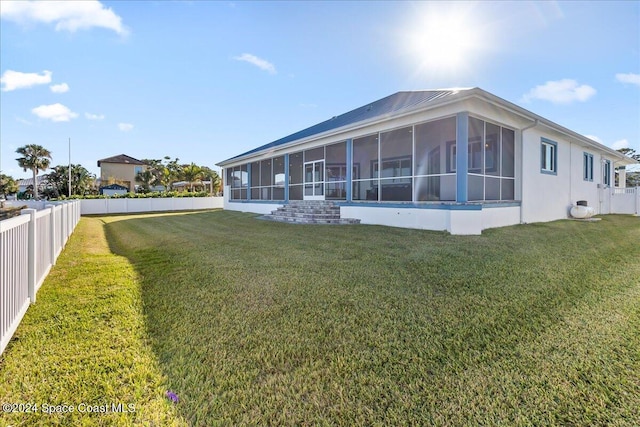 exterior space with a yard, a fenced backyard, and a sunroom