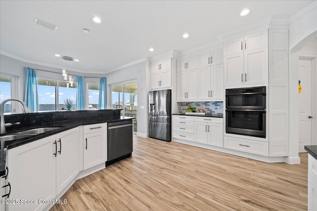 kitchen with visible vents, appliances with stainless steel finishes, crown molding, and a sink