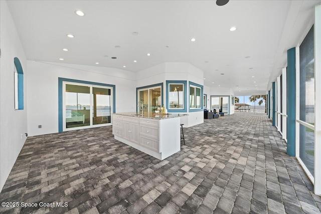 interior space featuring white cabinetry, plenty of natural light, recessed lighting, and open floor plan