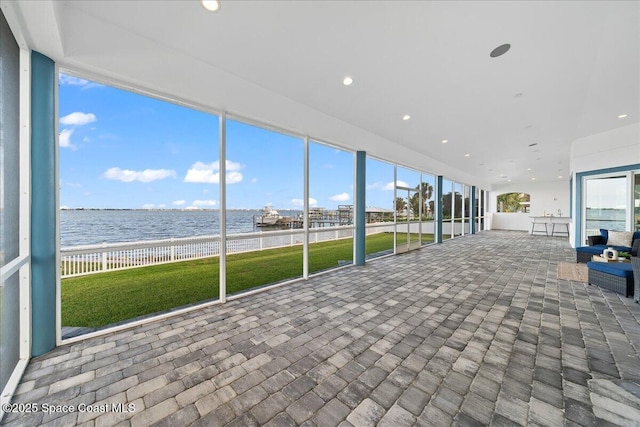 unfurnished sunroom with a water view