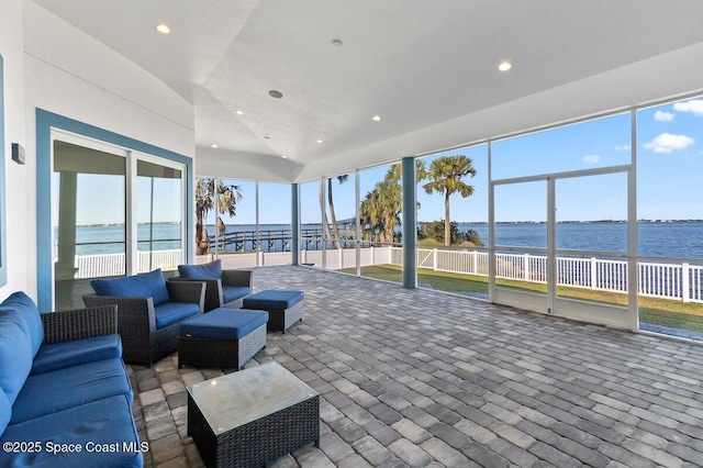 sunroom featuring a water view and lofted ceiling