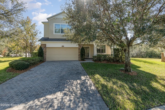 view of property hidden behind natural elements with a front lawn and a garage