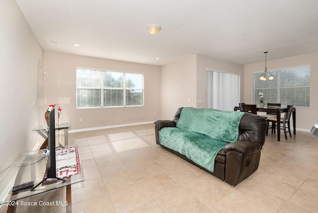 living room with light tile patterned floors and a notable chandelier