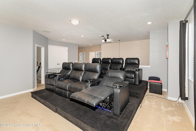 carpeted cinema room featuring a textured ceiling