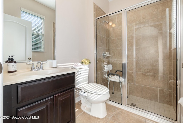 bathroom featuring tile patterned flooring, vanity, toilet, and an enclosed shower