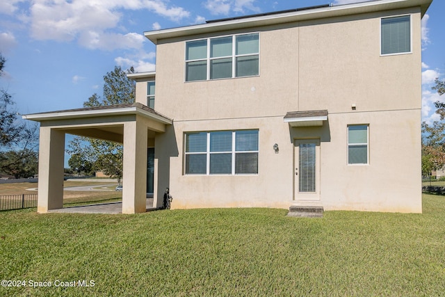 rear view of property featuring a lawn