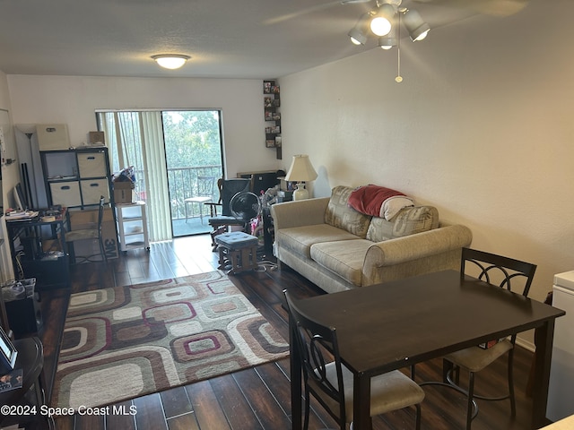 living room featuring ceiling fan and dark hardwood / wood-style floors