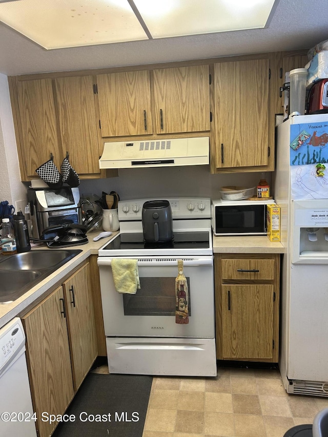 kitchen featuring sink, white appliances, and ventilation hood