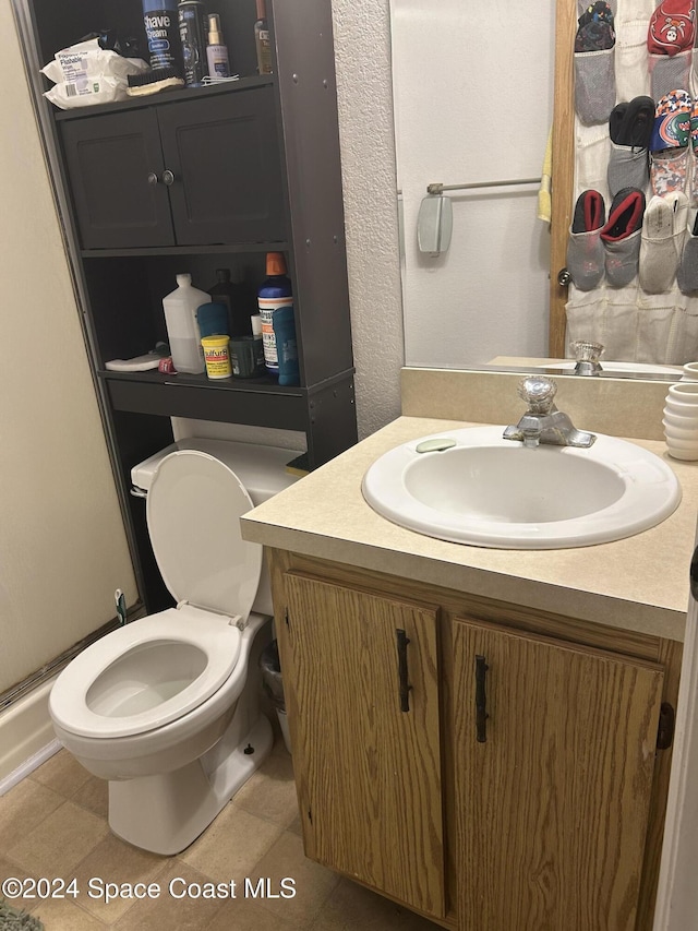 bathroom featuring tile patterned flooring, vanity, and toilet