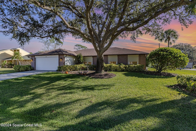 single story home featuring a yard and a garage