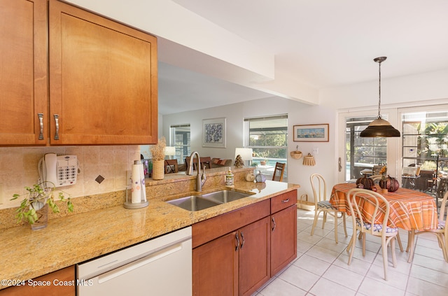 kitchen with a wealth of natural light, light stone countertops, dishwasher, and sink