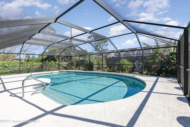 view of swimming pool with a patio and glass enclosure