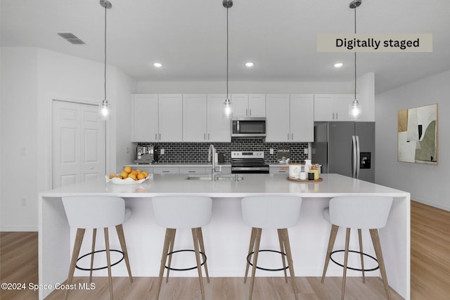 kitchen with a spacious island, stainless steel appliances, and decorative light fixtures