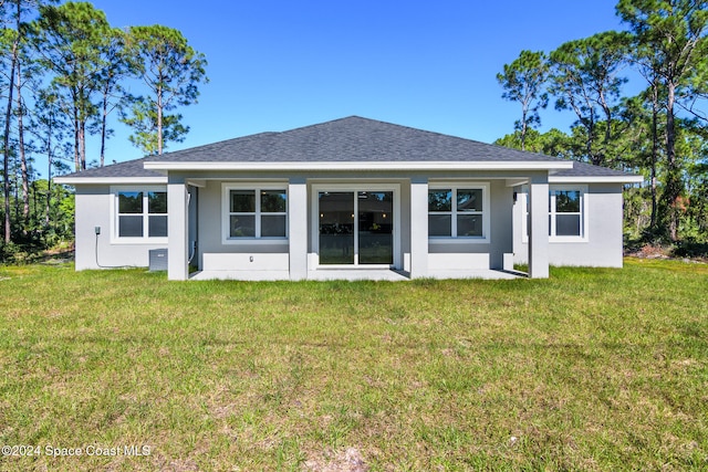 rear view of property featuring a lawn