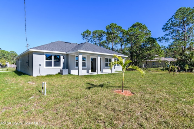 rear view of house featuring a lawn