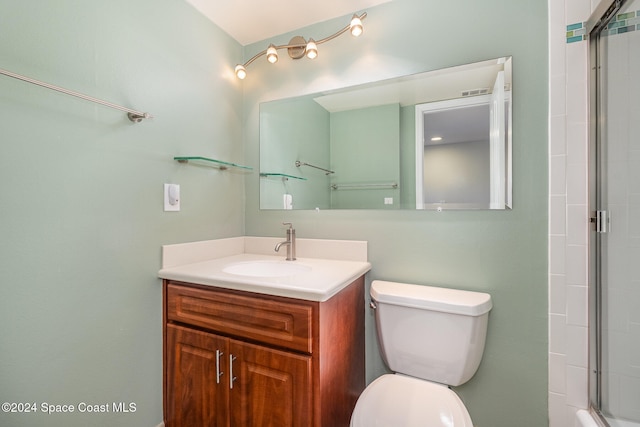 bathroom with vanity, toilet, and a shower with shower door