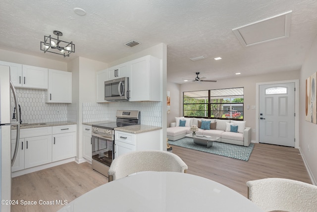 kitchen with white cabinetry, light hardwood / wood-style floors, and appliances with stainless steel finishes