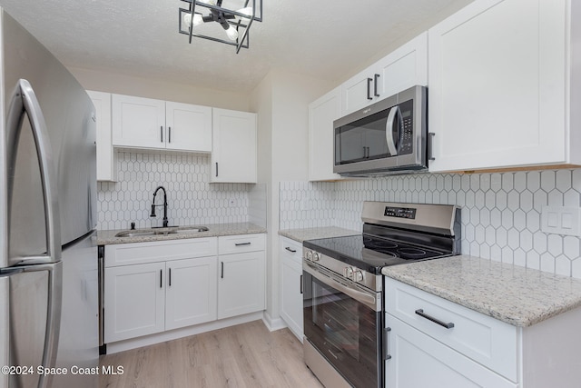 kitchen featuring sink, white cabinets, light wood-type flooring, and appliances with stainless steel finishes