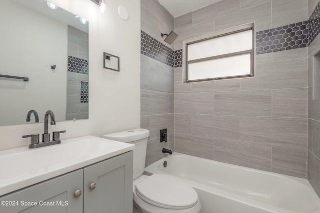 full bathroom featuring vanity, tiled shower / bath combo, and toilet