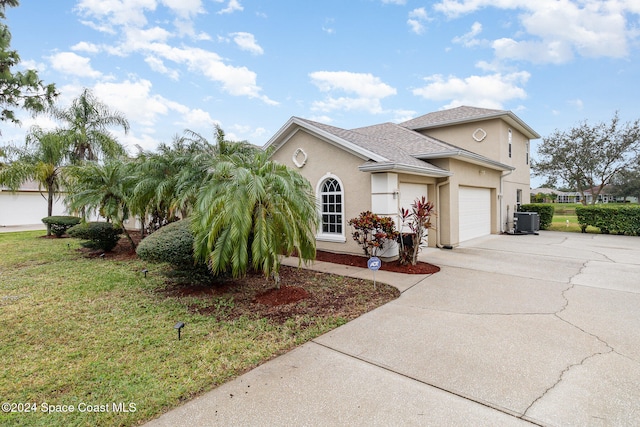 view of front of house featuring cooling unit, a garage, and a front yard