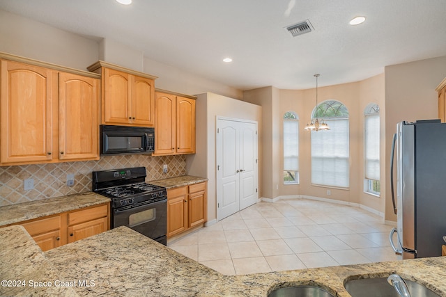 kitchen with backsplash, light stone counters, black appliances, pendant lighting, and a chandelier