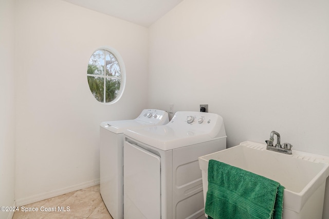 clothes washing area featuring light tile patterned floors, sink, and washing machine and clothes dryer