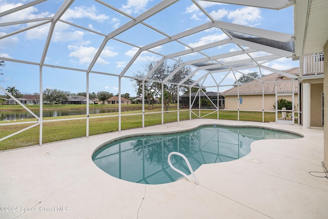 view of pool with a yard, a water view, a patio area, and a lanai