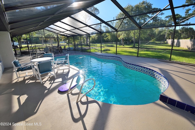 view of swimming pool with a lawn, a patio, and glass enclosure