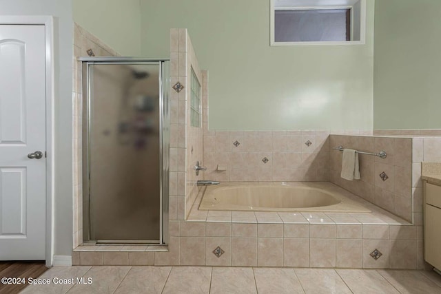 bathroom with tile patterned floors, vanity, and shower with separate bathtub