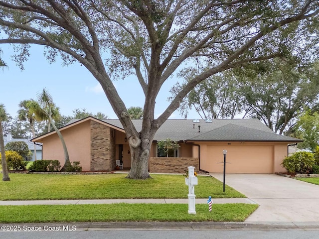 view of front of house with a garage, stucco siding, concrete driveway, and a front yard