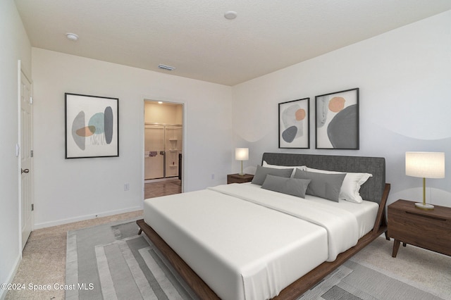 bedroom featuring a walk in closet, a closet, carpet, and a textured ceiling