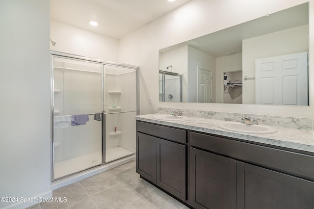 bathroom with tile patterned flooring, vanity, and a shower with shower door