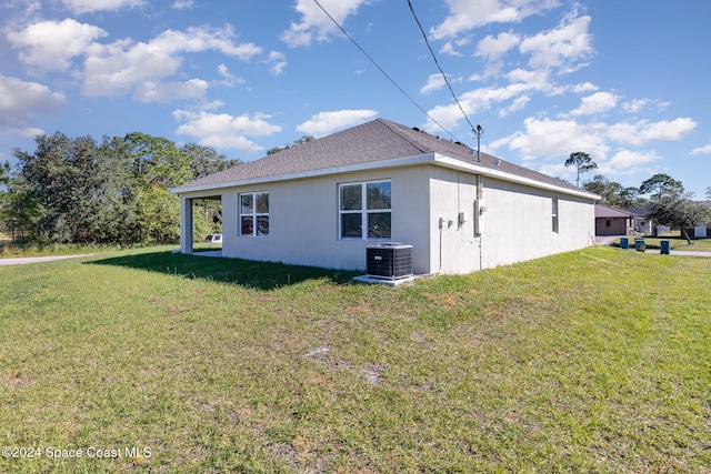 back of property featuring a yard and central air condition unit