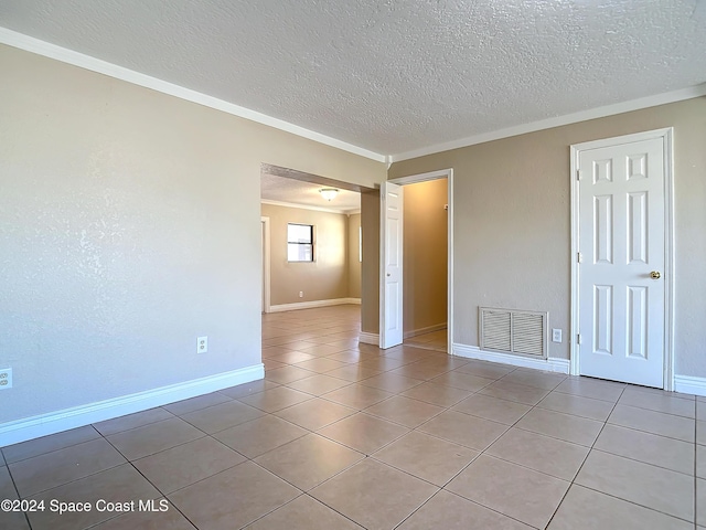 1037 Poinsetta St, Cocoa, FL 32927 - empty room featuring ornamental molding, tile patterned floors, a textured ceiling, and baseboards