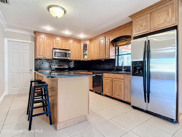 kitchen featuring sink, stainless steel appliances, a kitchen island, a breakfast bar, and light tile patterned flooring