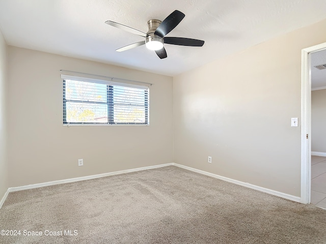 carpeted spare room featuring ceiling fan