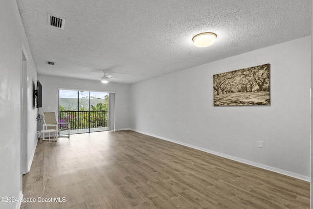 spare room featuring wood-type flooring, a textured ceiling, and ceiling fan