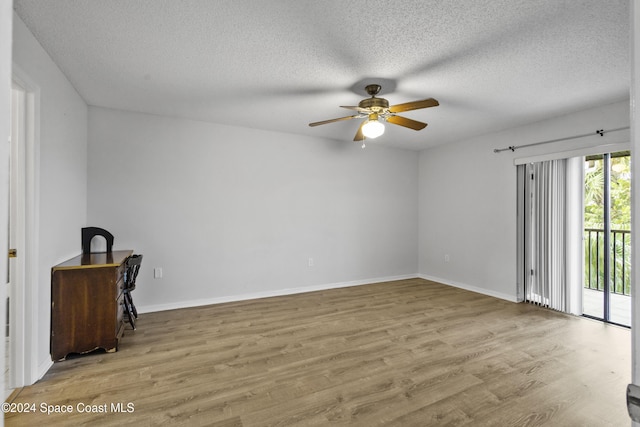 empty room featuring ceiling fan, light hardwood / wood-style floors, and a textured ceiling