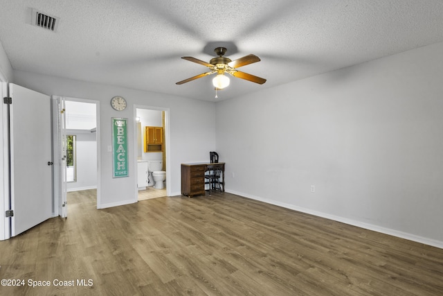 unfurnished room featuring hardwood / wood-style floors, ceiling fan, and a textured ceiling