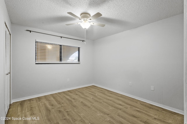 empty room with a textured ceiling, light hardwood / wood-style floors, and ceiling fan