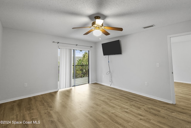 unfurnished room with hardwood / wood-style flooring, ceiling fan, and a textured ceiling