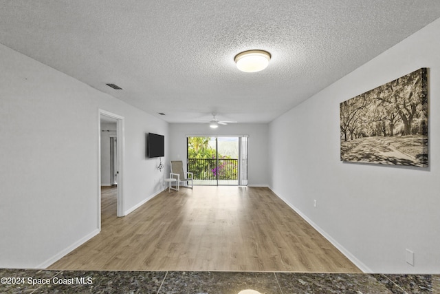 empty room featuring hardwood / wood-style floors, ceiling fan, and a textured ceiling