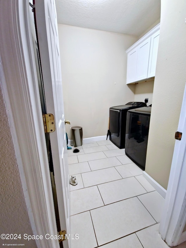 washroom featuring light tile patterned flooring, cabinets, and independent washer and dryer