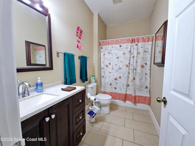 full bathroom with tile patterned floors, vanity, toilet, and shower / bath combo with shower curtain