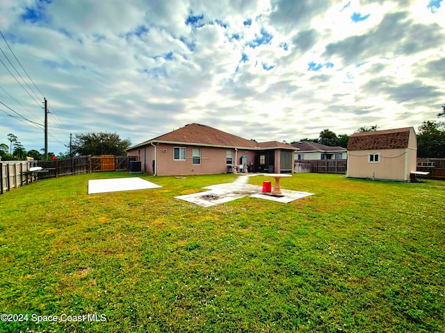 exterior space featuring a lawn, a patio area, and a shed