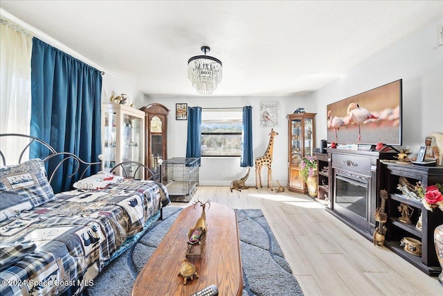 bedroom with light hardwood / wood-style flooring and a notable chandelier